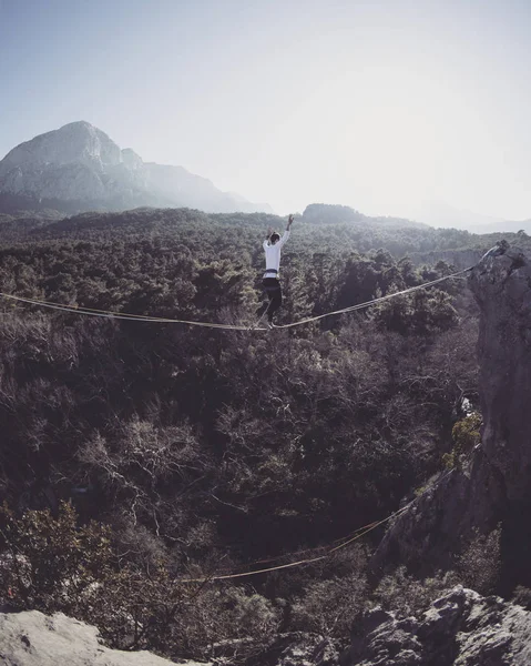 Bir adam gergin bir sapan boyunca yürüyor. Mounta Highline — Stok fotoğraf