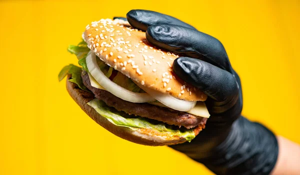 Hamburguesa Mano Guante Negro Sobre Fondo Amarillo — Foto de Stock