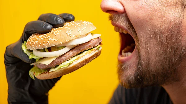 Man Wants Bite Burger Holding His Hand Black Glove Yellow — Stock Photo, Image