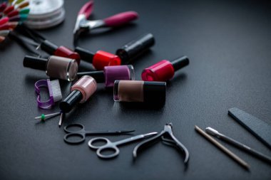 Siyah bir masa üzerindeki çivi, cila ve aletlerin bakımı için malzemeler