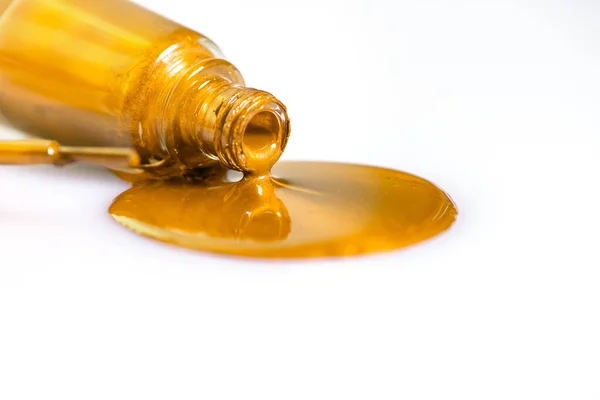 Altın oje beyaz bir masaya döküldü.