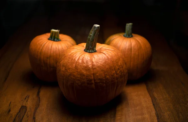 Három Narancs Tök Tölgyfa Asztalon Sötét Halloween Koncepció — Stock Fotó