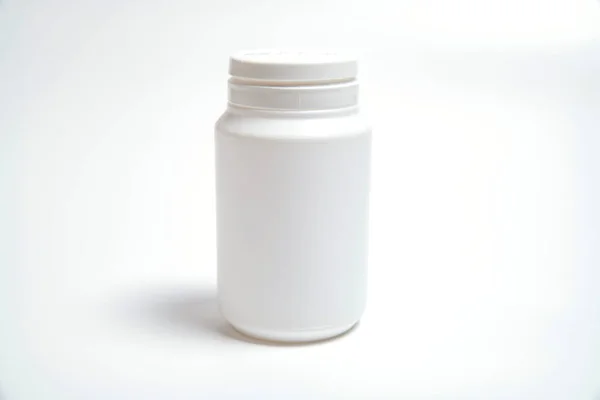 Beyaz arka planda hapların yazılı olduğu yazısız beyaz plastik tüp.