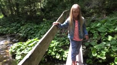 4 k turizm çocuk Geçiş Köprüsü Dağları'nda, ormanda yürüyüş üzerinde kız görünümü