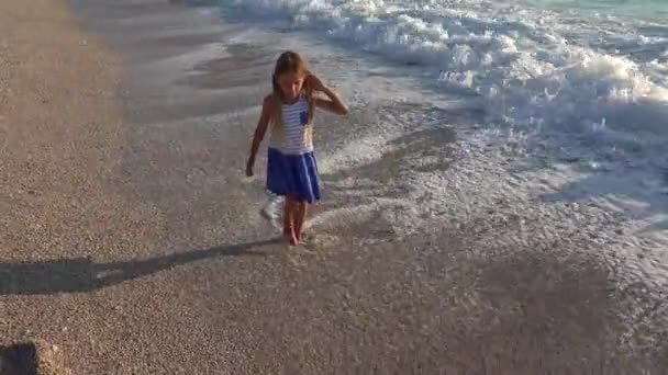 4 k kind spelen op strand, zee golven weergave, meisje lopen op de kustlijn in de zonsondergang — Stockvideo