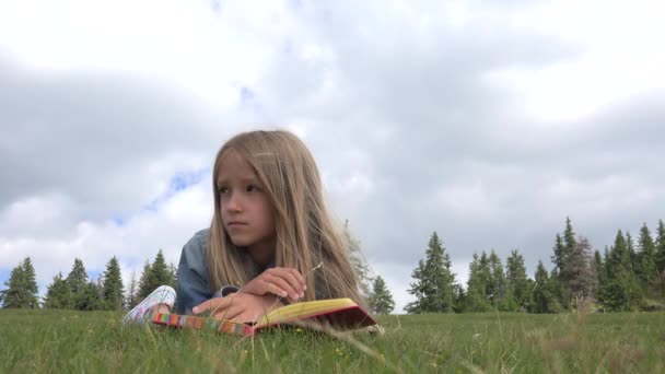 想着伤心的女孩在草地上看书 孩子在草地上学习户外 — 图库视频影像