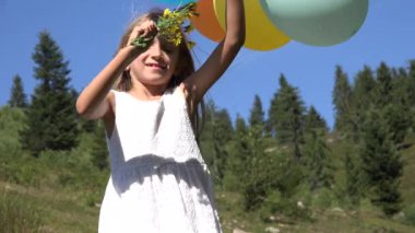 4k Park, çocuk sunan balonlu bir buket çiçek oynayan kız