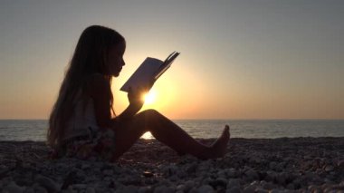 4 k kız okuma kitabı Beach, deniz kıyısı üzerinde Sunset View, sahil şeridi üzerinde çocuk