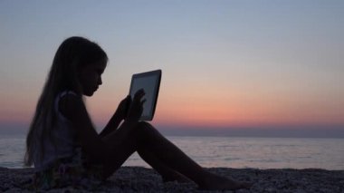 Tablet Beach, günbatımı, kız siluet, deniz manzarası 4 k güneş doğarken oynayan çocuk