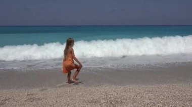Plaj, deniz oynayan çocuk görünümü, kız günbatımı 4 k içinde sahil şeridi üzerinde su dalgalar