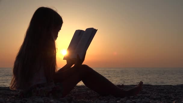 Kinderlesebuch am Strand, Blick auf den Sonnenuntergang, Mädchen an der Küste, Meer 4k