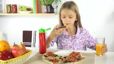 Sağlıksız yiyecek 4 k çocuk Pizza mutfak çocukta portakal suyu içme, yemek yiyor