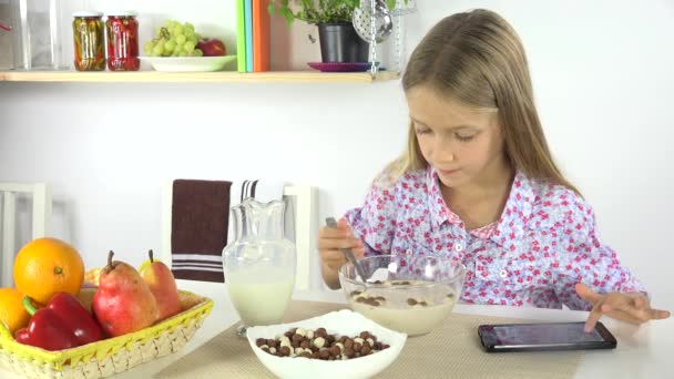 Kind Playing Tablet Eten Van Ontbijtgranen Met Melk Bij Het — Stockvideo