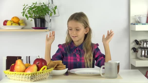 を食べるふりをしている子のキッチンで朝食を食べようとして空腹の少女 — ストック動画