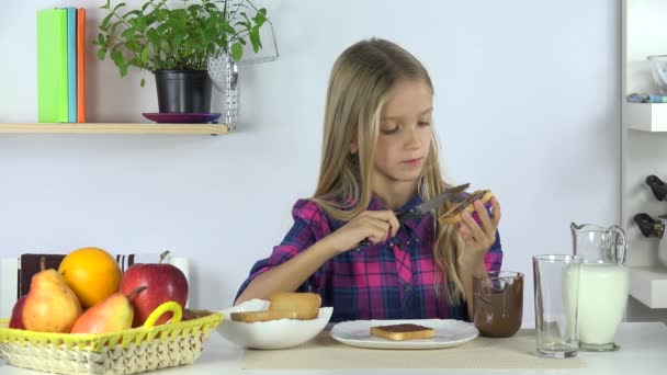 在厨房准备早餐的女孩 饥饿的孩子吃土司和巧克力4K — 图库视频影像