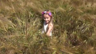 Buğday alanında, mutlu bir genç çocuk yüzü gülen, açık oynayan 4 k portre kız