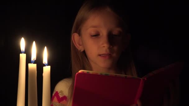 Lesendes Kind Bei Kerzen Gebetsmädchen Der Nacht Kinderporträt Gesicht Dunkelheit — Stockvideo