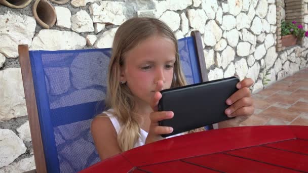 レストラン テラス で子顔サーフィン スマート フォンでタブレットを遊ぶ女の子 — ストック動画