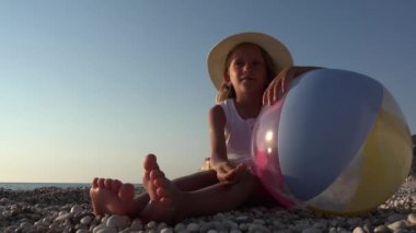 Kız plaj topu günbatımı, çakıl taşları ile oynayan kız yüz içinde tarafından 4 k portresi