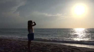 4 k kız sahilde günbatımı, çocuk siluet görünümü sahil şeridi üzerinde seyir oynamaktan