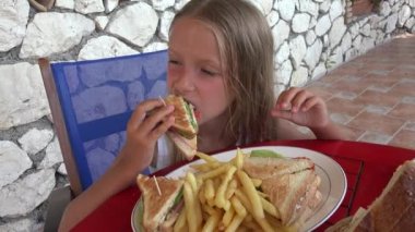 4 k çocuk sandviç ve patates kızartması Restaurant'ta yemek, kız cips yiyor