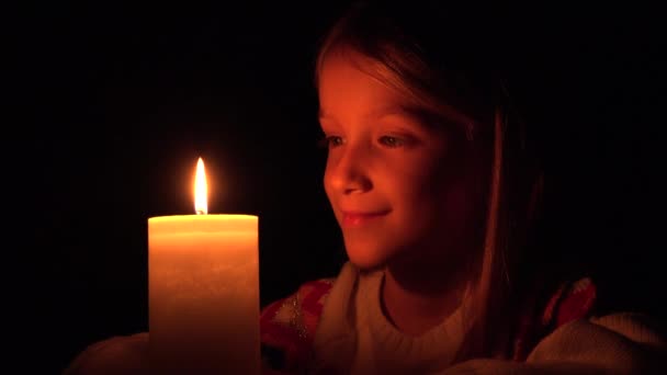 蝋燭と幸せな子 祈りの女の子が暗い で顔子供の肖像画 — ストック動画