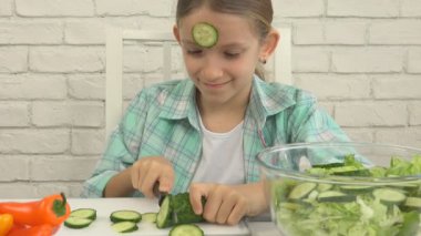 Çocuk mutfak, kız yiyor taze sebze, sağlıklı gıda yeşil salata hazırlık