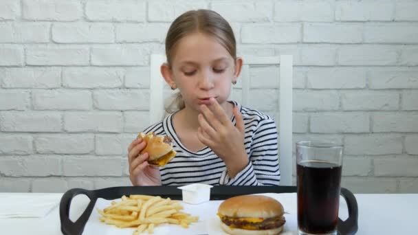 孩子吃汉堡包 在餐馆里炸薯条 孩子和快餐女孩喝果汁 — 图库视频影像