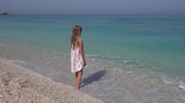 Kumsalda, kız deniz dalgaları, deniz manzarası izlerken çocuk oynayan çocuk