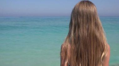 Kumsalda, kız deniz dalgaları, deniz manzarası izlerken çocuk oynayan çocuk