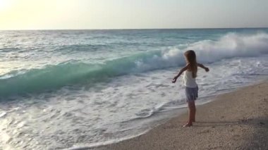 Plajda, kız dalgalar deniz, sahil üzerinde izlerken çocuk oynayan çocuk
