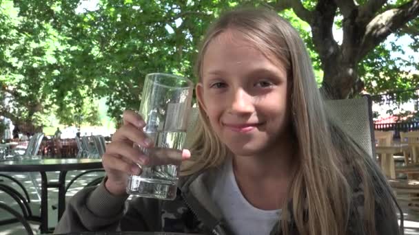 Kind drinkwater in Restaurant, Kid houden een glas Water, meisje glimlachend — Stockvideo