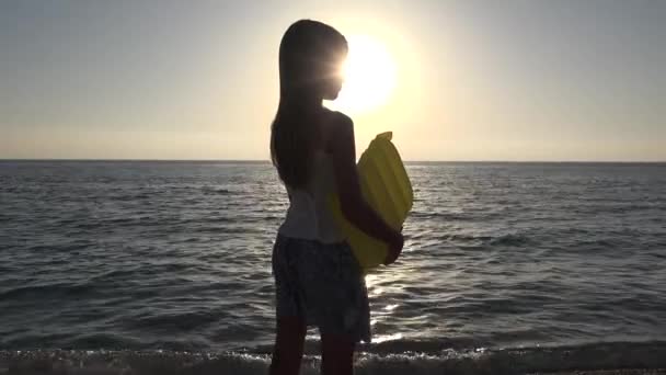 Kind spelen op het strand in zonsondergang, Kid Watching Sea Waves, Girl View bij zonsondergang — Stockvideo