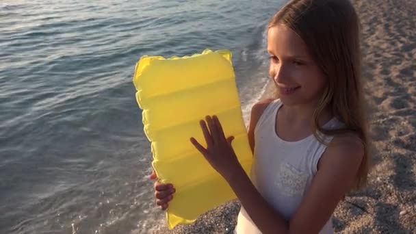 Kind spielt am Strand bei Sonnenuntergang, Kind beobachtet Meereswellen, Mädchen Blick bei Sonnenuntergang — Stockvideo