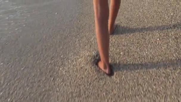 Niño jugando en la playa al atardecer, Chica feliz caminando en olas marinas en la playa — Vídeo de stock