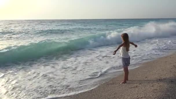 Kind, das am Strand spielt, Mädchen, das auf Meereswellen schaut, Kind, das am Strand zusieht — Stockvideo