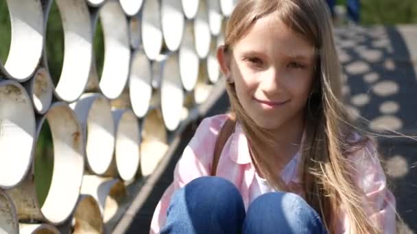 Niña pensativa en el parque, Niña pensativa al aire libre, Sonrisa triste en la cara del niño — Vídeo de stock