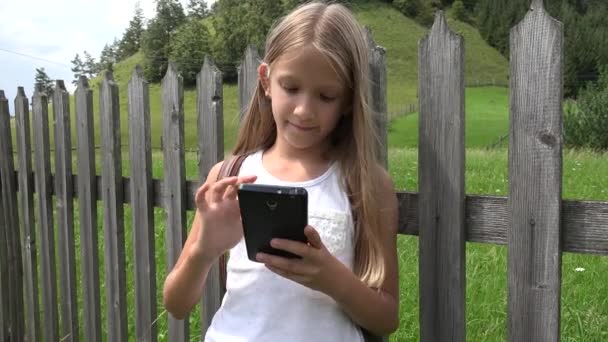 Criança jogando Smartphone ao ar livre, Criança em Tablet, Menina relaxante na natureza — Vídeo de Stock