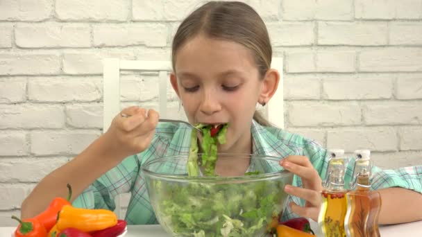 Το παιδί τρώει σαλάτα στην κουζίνα, το κορίτσι τρώει φρέσκα λαχανικά, υγιεινά τρόφιμα — Αρχείο Βίντεο