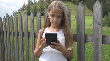 Smartphone açık, oynayan çocuk çocuk tablet, kız doğada rahatlatıcı