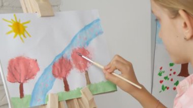 Şövale üzerinde atölye sınıftaki kız resim sanatı çalışma okul çocuk boyama çocuk