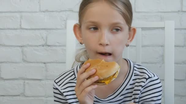 子供のレストランでハンバーガーを食べる子供が食べる迷惑ファーストフード空腹少女 — ストック動画