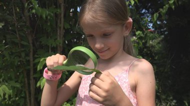 Bir tırtıl büyüteç doğa, oynayan kız öğrenci açık tarafından okuyan çocuk
