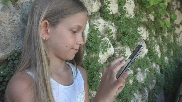 Barn Leker Smartphone Stenmur Gården Lilla Flickan Använder Tablet Utomhus — Stockfoto
