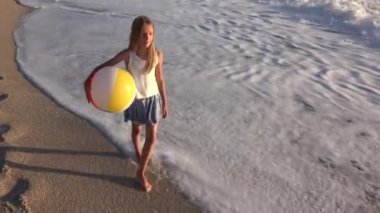 Kumsalda gün batımında, deniz dalgaları kız deniz yürüme çocuk mutlu oynayan çocuk