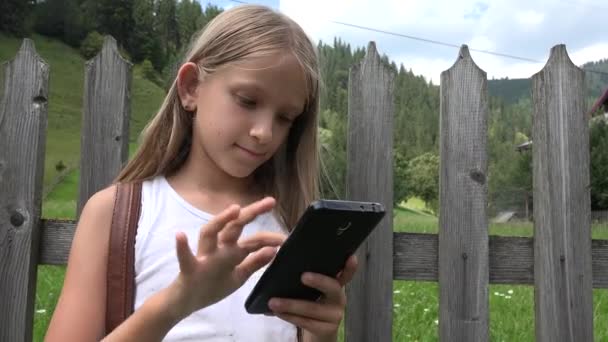 孩子玩智能手机户外 孩子在片剂 女孩放松在自然 — 图库视频影像