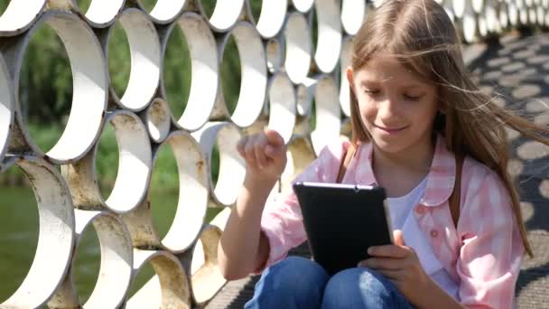 Niño Jugando Tableta Parque Niña Utiliza Teléfonos Inteligentes Aire Libre — Vídeo de stock