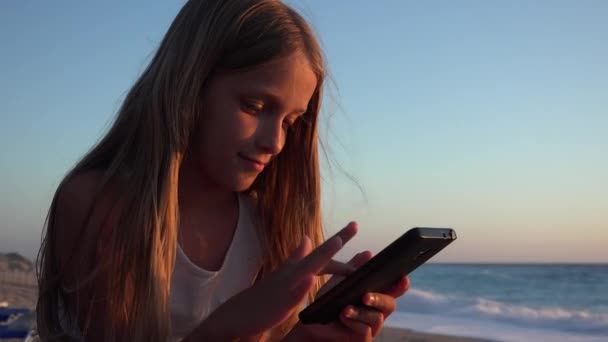 Barnlek Smartphone Kid Stranden Vid Solnedgången Flicka Med Surfplatta Stranden — Stockvideo