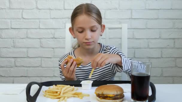 Eszik hamburgert étterem, a gyerek és a Fast Food, lány ivás lé a gyermek