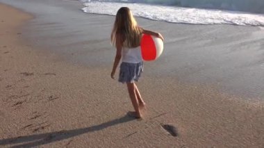 Kumsalda gün batımında, deniz dalgaları kız deniz yürüme çocuk mutlu oynayan çocuk